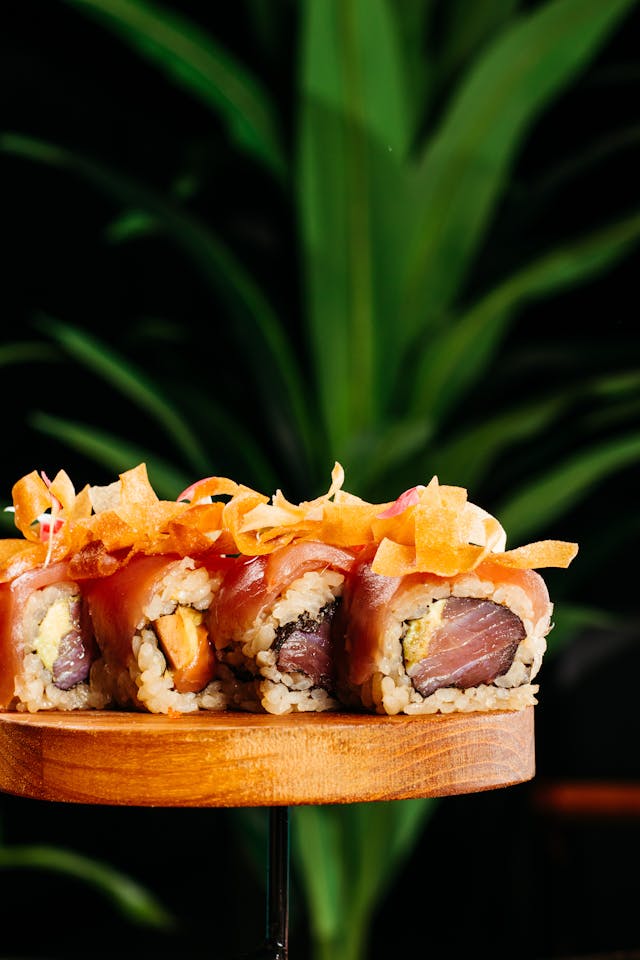 Salmon roll decorated with carrot on top.